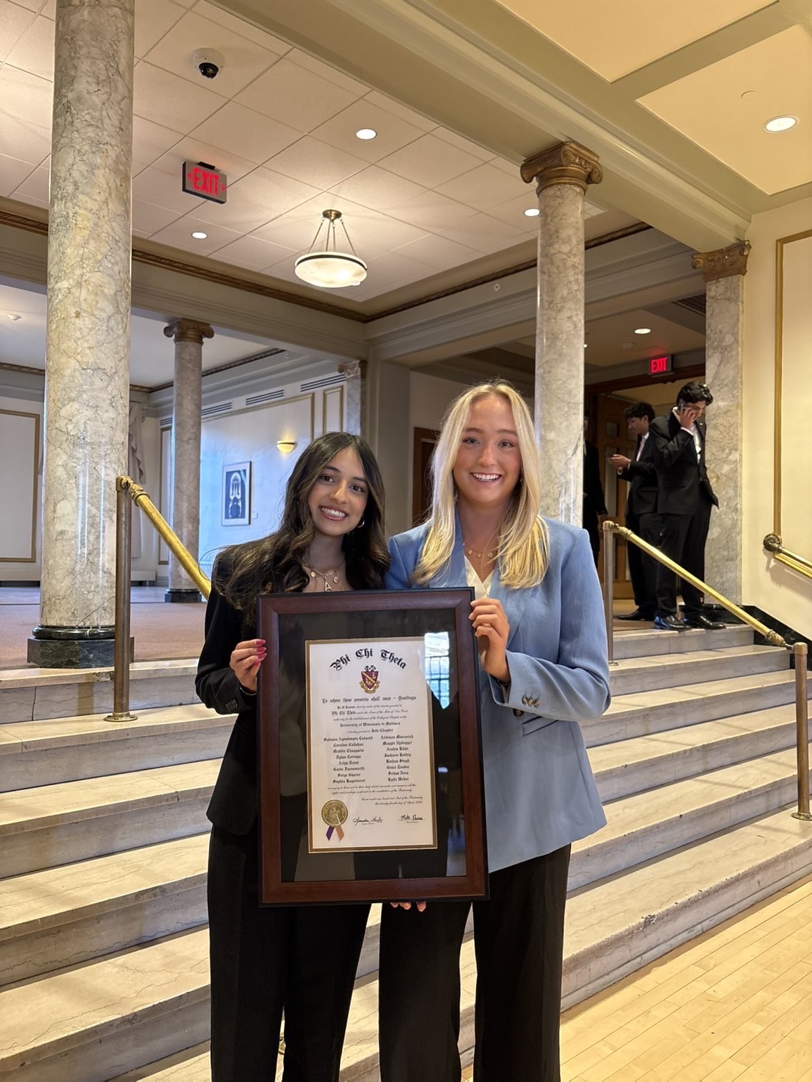 Maddie and Ariya holding the Iota Chapter charter